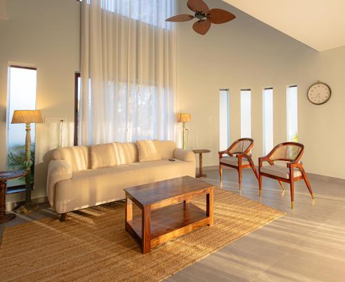a living room with a couch and two chairs at Quad Club - Resort and Spa, Nandi Hills in Nandigunda