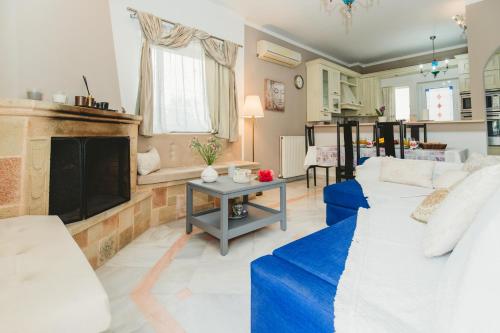 a living room with a couch and a fireplace at Villa Irene, Lindos 10 mins, beach 4 mins in vlicha