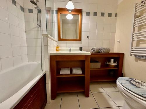 a bathroom with a tub and a sink and a toilet at nid douillet au milieu des pins entre lac et océan in Carcans