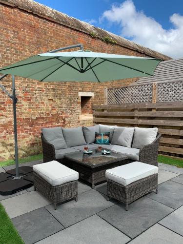 a patio with a couch and an umbrella at Fort View- Totland in Totland