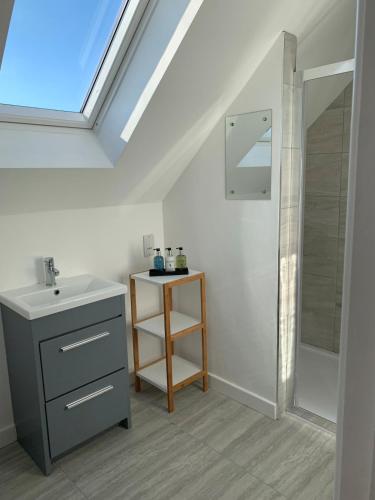 a bathroom with a sink and a shower and a mirror at Fort View- Totland in Totland