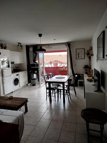une cuisine et un salon avec une table et des chaises dans l'établissement Superbe Appartement Terrasse Plein Sud, à Urrugne