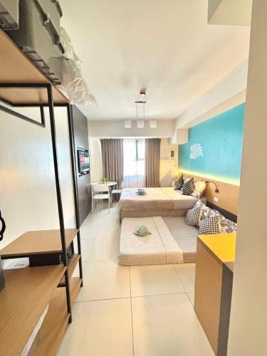 a bedroom with two beds and a living room at Horizons 101 Fab Condotel in Cebu City