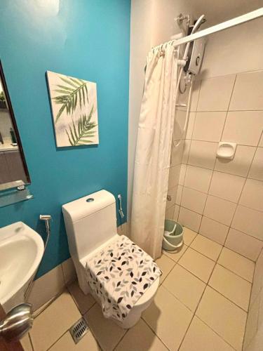 a bathroom with a white toilet and a sink at Horizons 101 Fab Condotel in Cebu City