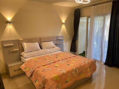 a bedroom with a large bed with an orange comforter at Studio with stunning view in Vernada Sahl Hasheesh in Hurghada
