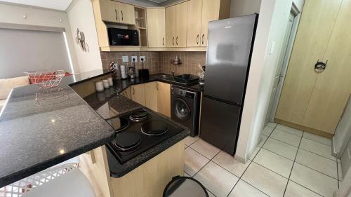 a kitchen with a black refrigerator and a stove at La Caribe Unit 01 in Jeffreys Bay
