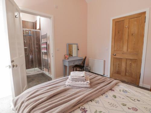 ein Schlafzimmer mit einem Bett mit einer Decke darauf in der Unterkunft Morton Mains Steading Cottage in Thornhill