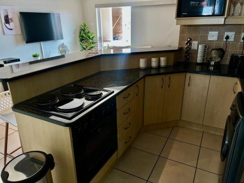 a kitchen with a black stove top oven at La Caribe Unit 01 in Jeffreys Bay