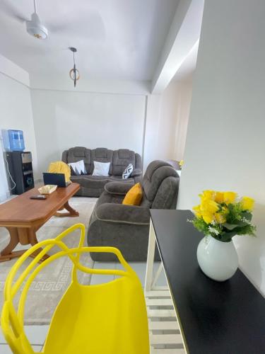 a living room with a couch and a table with a yellow bag at Homely Hideaway Buxton Point Mombasa in Mombasa