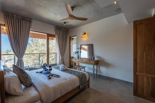 PaudThe Foresta Resort ,Mulshi的一间卧室配有一张带吊扇和窗户的床。