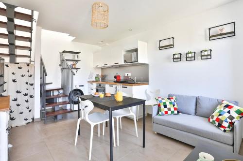 un salon avec une table et un canapé dans l'établissement L'évasion, terrasse parking, à Zillisheim