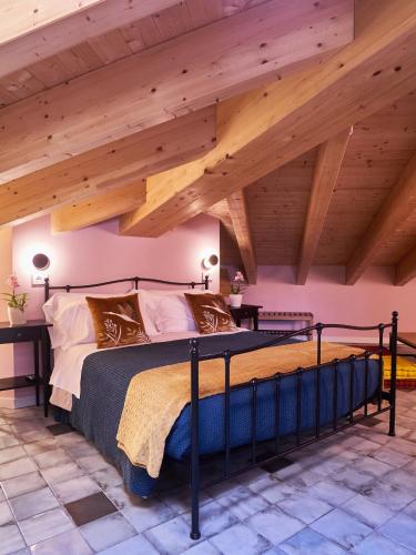 a bedroom with a large bed with wooden ceilings at Ca' Martini Apartments in Peschiera del Garda