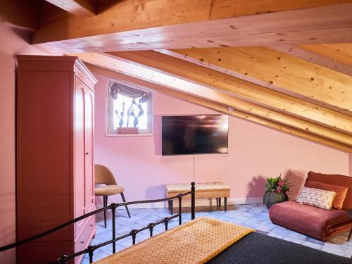 Una sala de estar con techos de madera y televisión. en Ca' Martini Apartments, en Peschiera del Garda