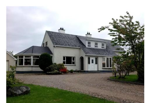 a white house with a black roof at Cloncha House B&B in Culdaff