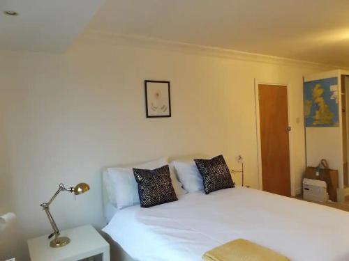 a bedroom with a white bed with a lamp on it at Spacious Bright Room in Coventry in Coventry