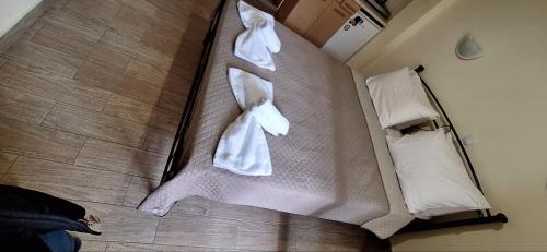 a bed with two white towels on it at DIOLKOS APARTEMENT in Nea Roda