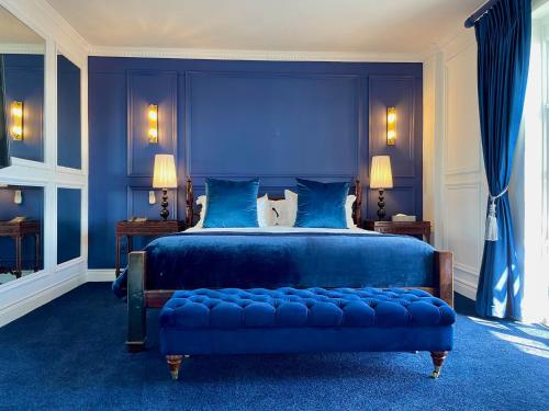 a blue bedroom with a large bed with a blue headboard at Romney Park Luxury Apartments by The Stay Collection in Cape Town