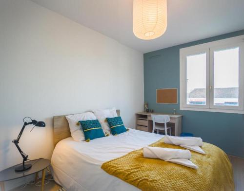 une chambre avec un grand lit aux murs bleus dans l'établissement L'Anatole Wifi Parking, à Troyes