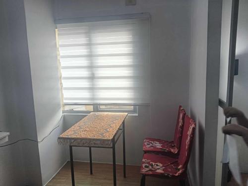 a table and a chair in a room with a window at Xian's place Budget Friendly Condo in Manila