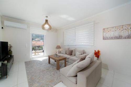 a white living room with a couch and a table at Ozone Complex by A&D Properties in Porto Rafti