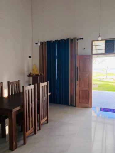a dining room with a table and a blue curtain at Lago Inn in Tissamaharama