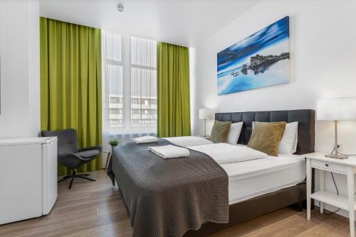 a bedroom with a large bed with green curtains at Iceland Comfort Apartments by Heimaleiga in Reykjavík