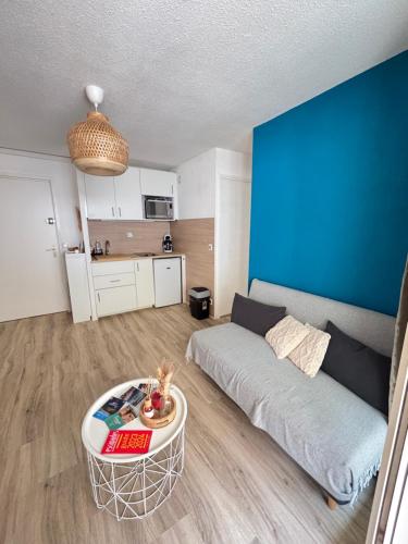 un salon avec un canapé et une table dans l'établissement Appartement Gruissan climatisation et piscine, à Gruissan