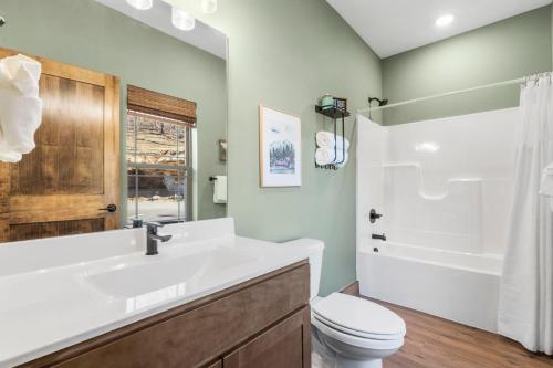 a bathroom with a sink and a toilet and a shower at New Cabin at Tall Timbers! Free Tickets! Indoor and Outdoor Pools! in Hollister