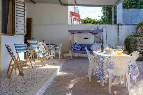 a patio with a table and chairs and a fireplace at Alla Rosa Dei Venti - North Wind House in Torre Specchia Ruggeri