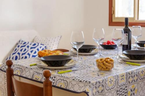 a table with plates of food and wine glasses at Alla Rosa Dei Venti - North Wind House in Torre Specchia Ruggeri