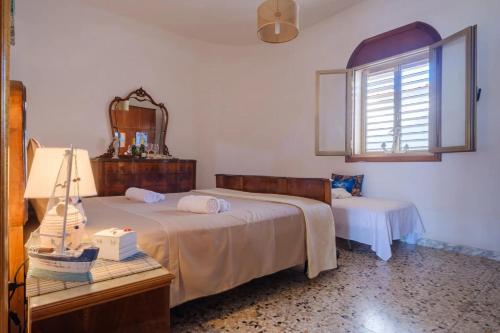 a bedroom with two beds and a table with a mirror at Alla Rosa Dei Venti - North Wind House in Torre Specchia Ruggeri