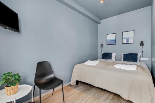 a bedroom with a bed and a black chair at Iceland Comfort Apartments by Heimaleiga in Reykjavík