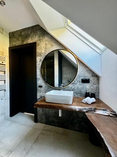 a bathroom with a sink and a mirror at Bacówki Resort in Ochotnica Górna