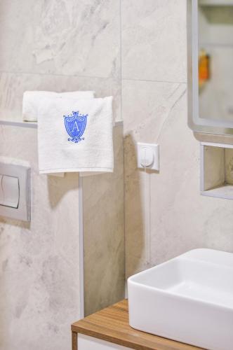 a bathroom with a white sink and a towel at Alexander Resort in Sopot