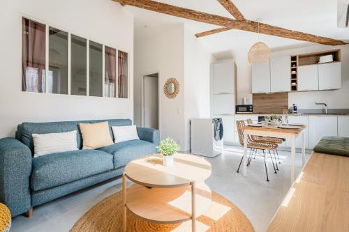 un salon avec un canapé bleu et une table dans l'établissement Nistoun par Dodo à Cassis, à Cassis