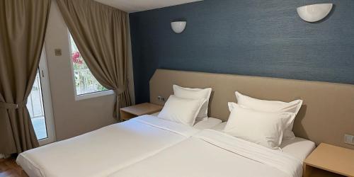 a bedroom with a large bed with white sheets and pillows at Holiday Village Interpark in Kranevo