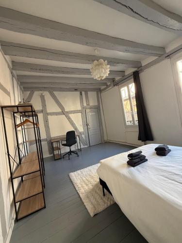 1 dormitorio con cama, escalera y silla en Appartement 6 personnes, en Vierzon