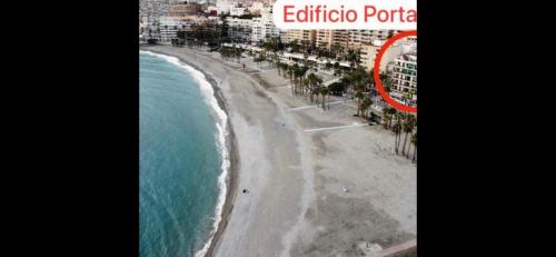 - une vue aérienne sur une plage bordée de palmiers et un bâtiment dans l'établissement Apartamento 60, à Almuñécar