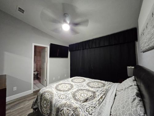 a bedroom with a bed and a ceiling fan at The Duke's Castle with Garage & Fast Internet in Dallas
