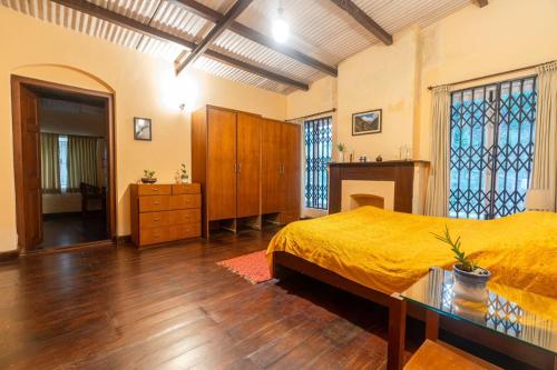 a bedroom with a bed and a dresser at Shanthiniketan Heritage in Coonoor