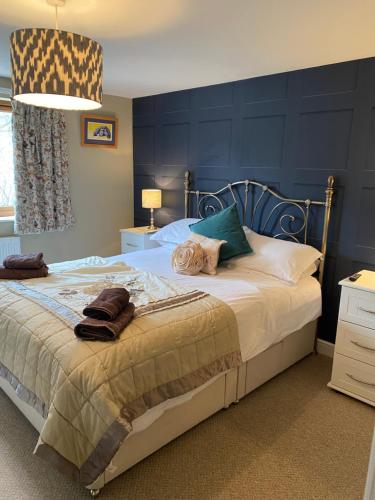 a bedroom with a large bed with blue walls at 4 beds, private parking, gr fl bedroom & shower WC in Wensley