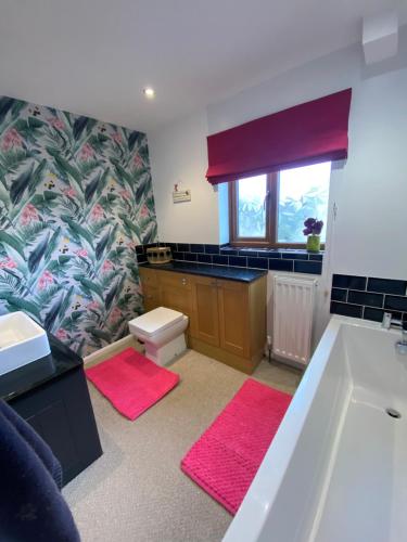a bathroom with a tub and a sink and a window at 4 beds, private parking, gr fl bedroom & shower WC in Wensley