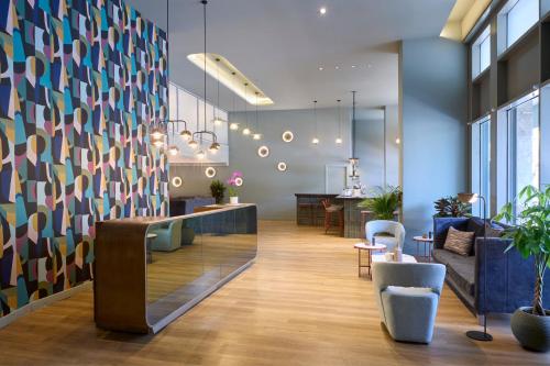 a lobby with blue walls and chairs and a reception desk at Wyndham Athens Residence in Athens