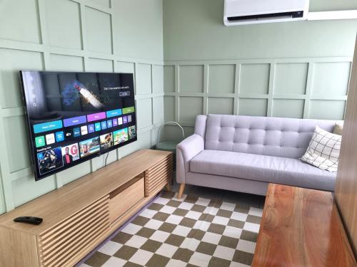 a living room with a couch and a flat screen tv at Newly Furnished Condominium in the Heart of Quezon City near Top Philippine Hospitals in Manila