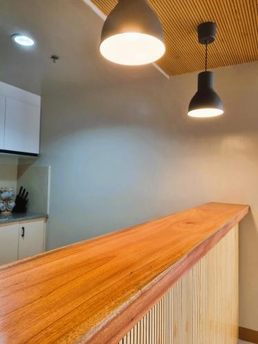 a kitchen with a wooden counter top and two lights at Newly Furnished Condominium in the Heart of Quezon City near Top Philippine Hospitals in Manila