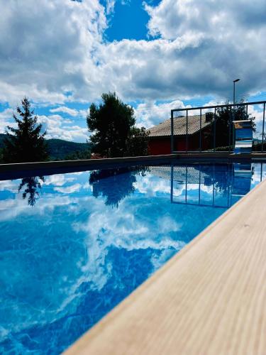 a swimming pool with a reflection of the sky in the water at La Dacha Montanya in Seva