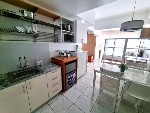 a kitchen with a sink and a table with chairs at Newly Furnished Condominium in the Heart of Quezon City near Top Philippine Hospitals in Manila