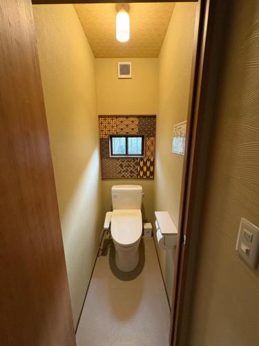 a small bathroom with a toilet and a window at Shiraito Garden A Private Retreat Near Shiraito Falls with Mt Fuji Views in Fujinomiya