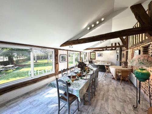 une salle à manger avec une table, des chaises et des fenêtres dans l'établissement La Commanderie et son Cottage PISCINE - SAUNA - 12pers, à Le Sap-André