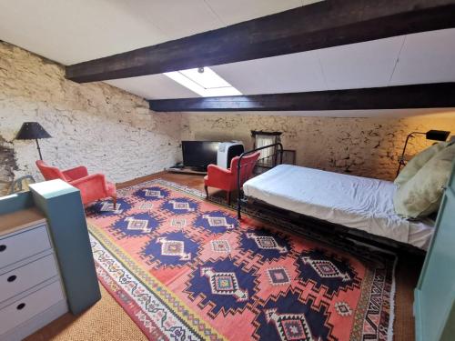 - une chambre avec un lit, des chaises rouges et un tapis dans l'établissement Maison Figue, maison de village Aspiran, l'Hérault, à Aspiran